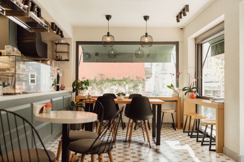 Tavoli e dettagli di un piccolo caffè luminoso. Fotografia d’ispirazione.